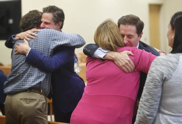 Plaintiff William Sherlach, left, hugs attorney Josh Koskoff while plaintiff Nicole Hockley hugs attorney Chris Mattei following the jury verdict and reading of monetary damages in the Alex Jones defamation trial at Superior Court, Wednesday, Oct. 12, 2022, in Waterbury, Conn. (Brian A. Pounds/Hearst Connecticut Media via AP, Pool)