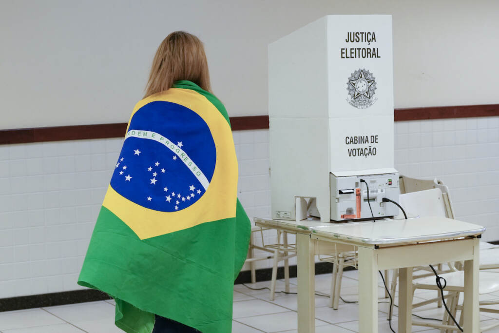 Brazil Elections A voter wrapped in a Brazilian flag arrives to vote in a presidential a run-off pitting President Jair Bolsonaro against former President Luiz Inácio Lula da Silva, in Brasilia, Brazil, Sunday, Oct. 30, 2022. (AP Photo/Eraldo Peres)