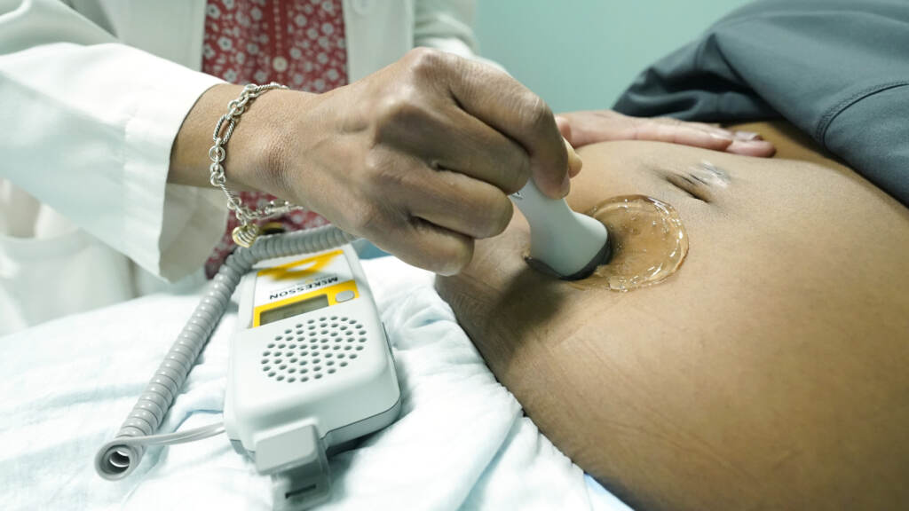 A midwife at Sisters in Birth, a Jackson, Miss., clinic that serves pregnant women, uses a hand-held doppler probe on a patient from Yazoo City to measure the heartbeat of her fetus in 2021. An up-close look at a midwife performing an ultrasound.