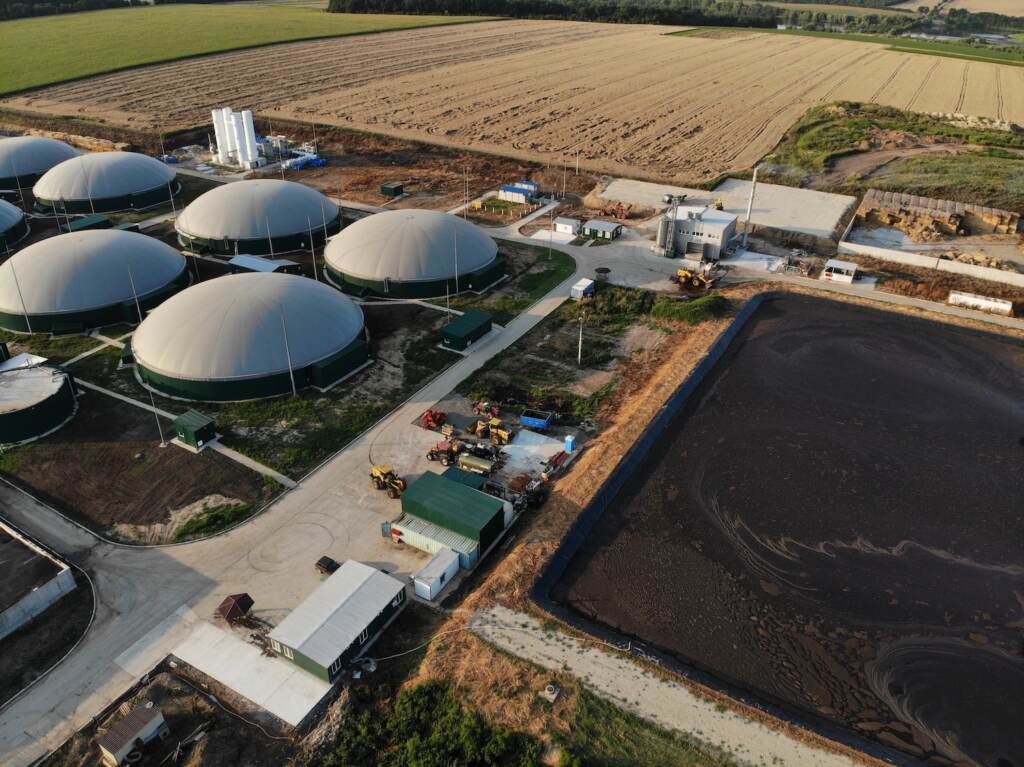 Aerial View Over Biogas Plant And Farm In Green Fields. Renewable Energy From Biomass. Modern Agricu Aerial view of a biogas plant.