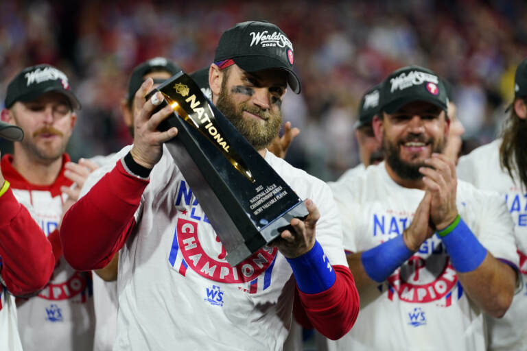 Bryce Harper holds up a trophy after the Phillies win the NLCS