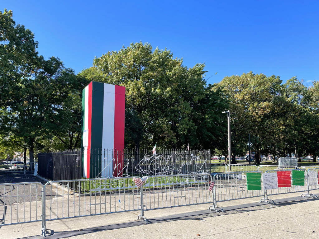 A box painted in red, white, and green is enclosed in a barricade.