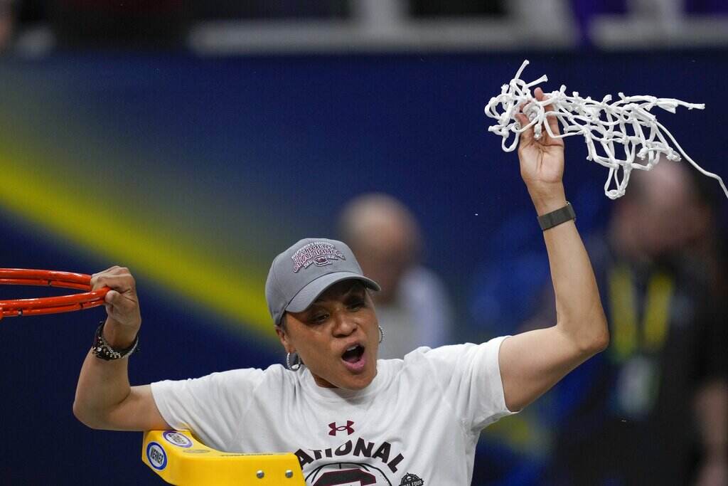 Dawn Staley Leadership Award Basketball Dawn Staley holds up the net cut from the basketball hoop.