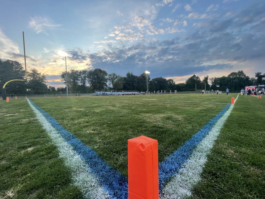 dickinson-high-school-football-c-barrish-2022-01-07-18 Players on a field are visible in the background.