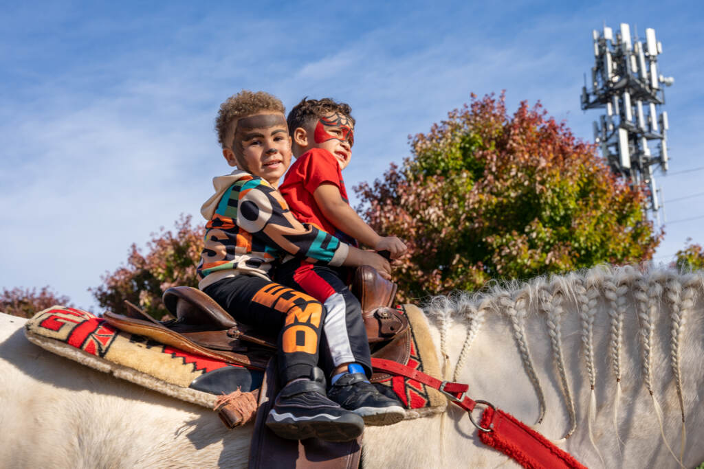 Two children are seated on a horse.