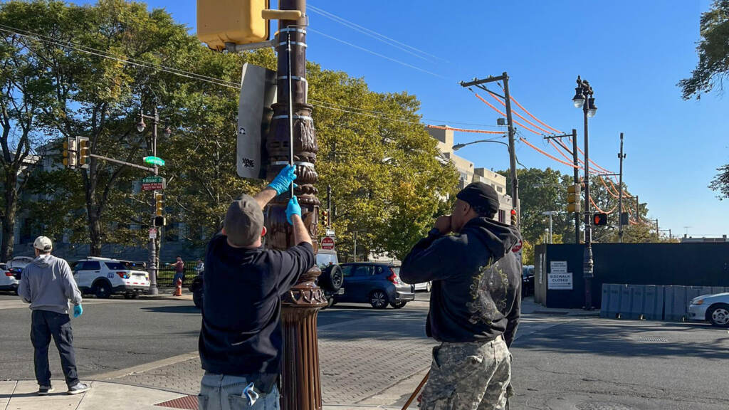 greasingpoles City workers grease a light pole on a sunny day.