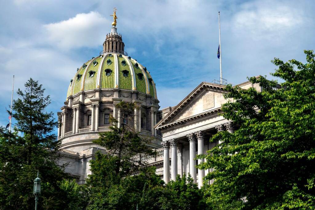 The dome of the State Capitol in Harrisburg with trees.