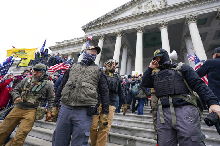People stand in front of the U.S. Capitol building during the Capitol riot on Jan. 6, 2021.