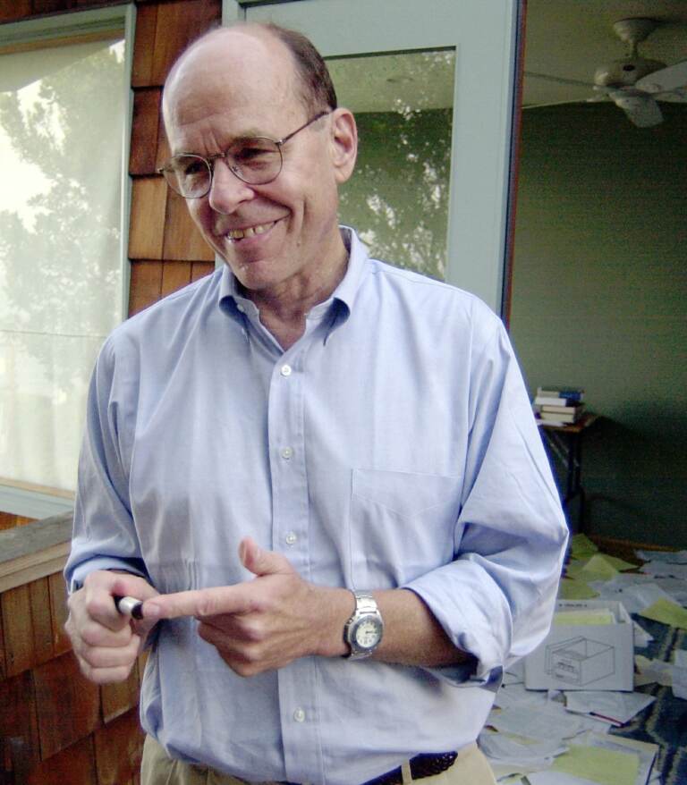 K. Barry Sharpless points to a sample used in his work, as he stands on the balcony outside of his home office
