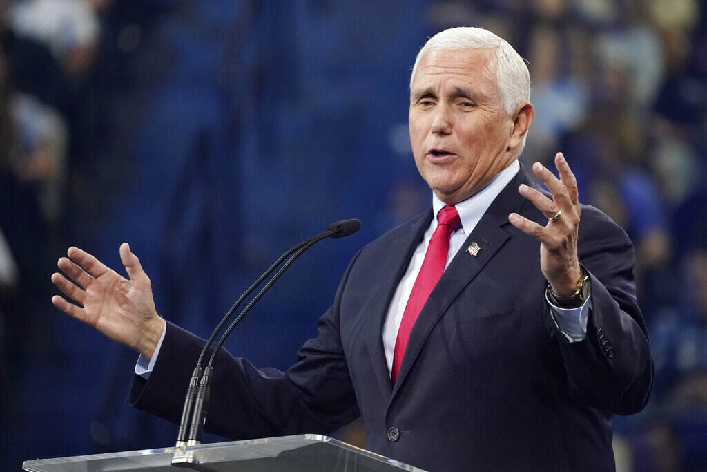 Mike Pence Mike Pence speaks at a podium with his hands raised.