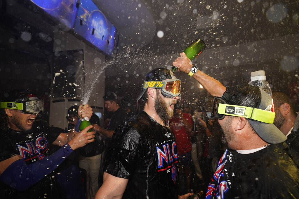 NLDS Phillies Braves Baseball Philadelphia Phillies Bryce Harper, center, is doused in booze in the locker room