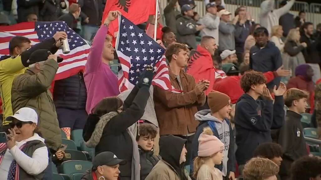 philly-unity-cup Fans cheer, and wave a U.S. flag.