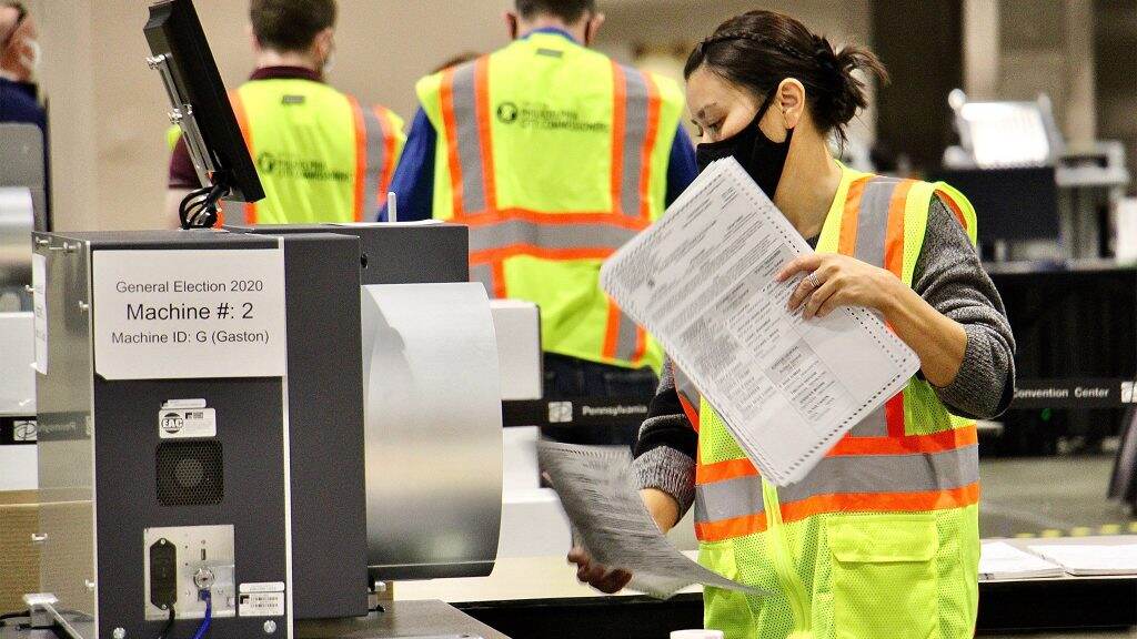 phillyelection2020-ballotcounting-conventioncenter-01-1024×576 An election worker holds a mail ballot.