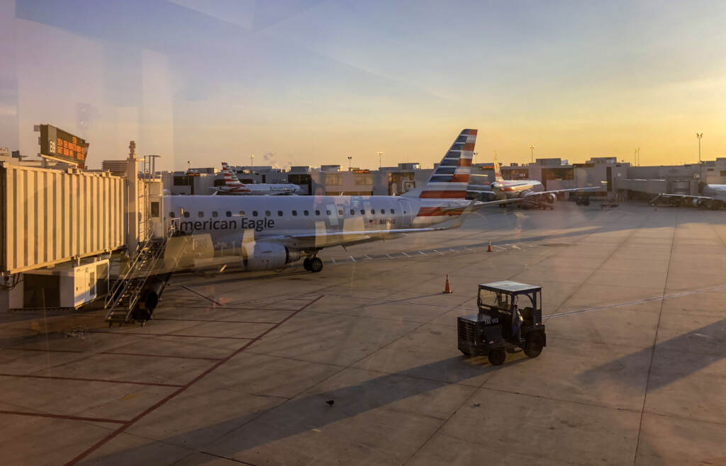 phlairport-plane An airplane is seen pulling up to a gate at sunset.