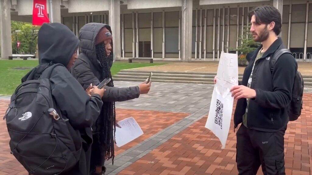 templestudent-electionday-petition-jaredgoldberg-2-1024×576 Temple students scan the QR code for Jared Goldberg's petition to cancel classes on Election Day to help get out the vote. Nearly 5,000 people signed, and the university will form a working group to explore the idea. (Temple Update)