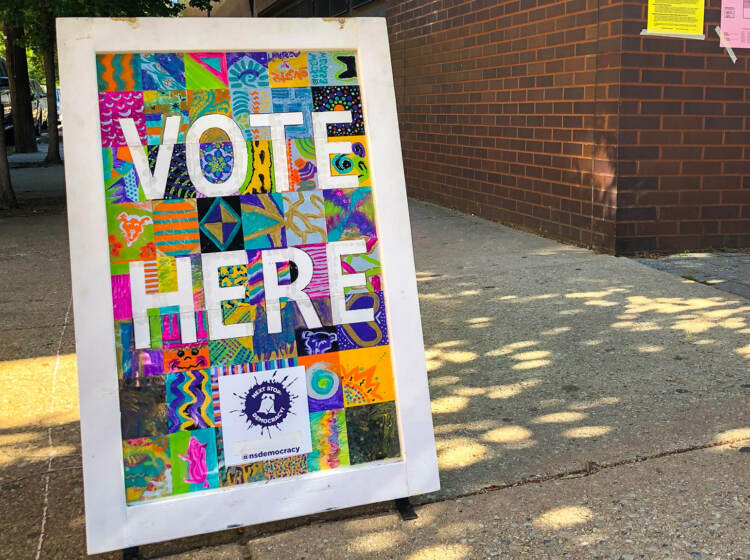 A sign reads Vote Here.