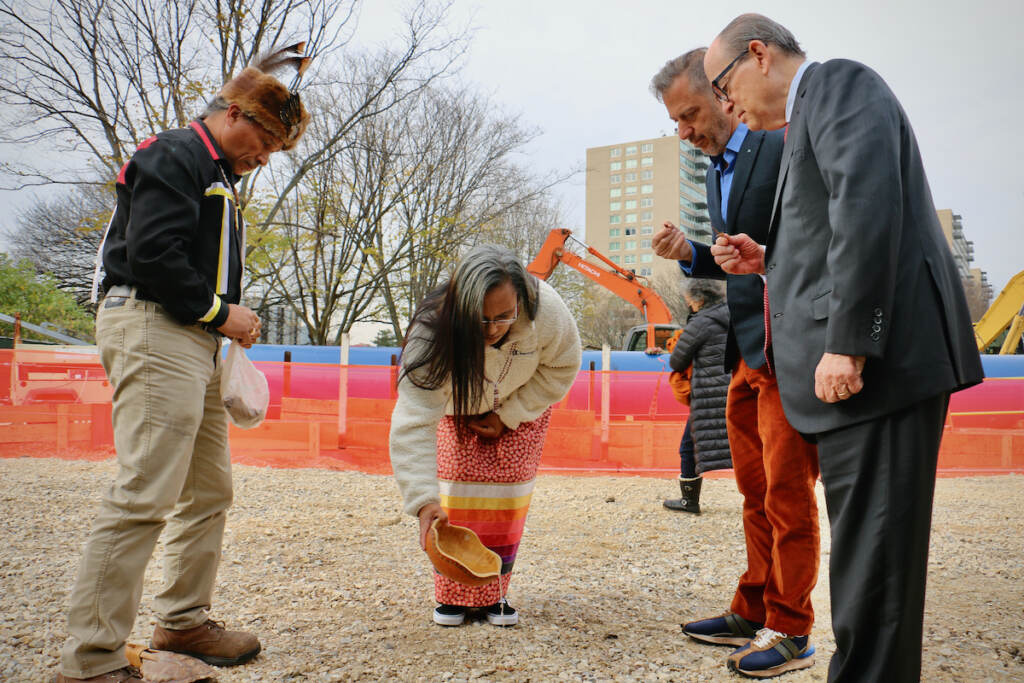 2022 11 15-e lee-urie ridgeway denise bright dove ashton dunkley alexander rower joseph neubauer-philadelphia ben franklin parkway calder gardens-groundbreaking ritual Denise Bright Dove Ashton-Dunkley (center) pours water on the ground where Calder Gardens will be constructed during a ritual drawn from Nanticoke Lenni-Lenape tradition. Joining her are Urie Ridgeway (left), philanthropist Joseph Neubauer (right) whose efforts brought the Calder museum to fruition, and Alexander S. C. Rower, grandson of the sculptor Alexander Calder. (Emma Lee/WHYY)