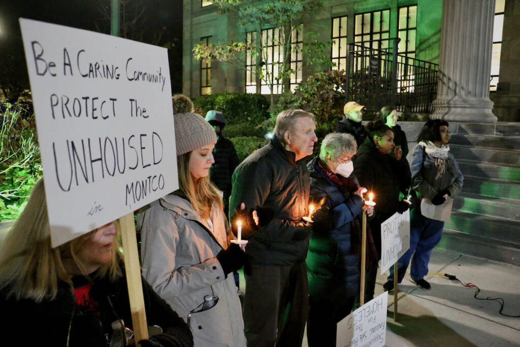 2022 11 16-e lee-norristown pa montgomery county courthouse-homeless night signs People hold candles at night in the cold.