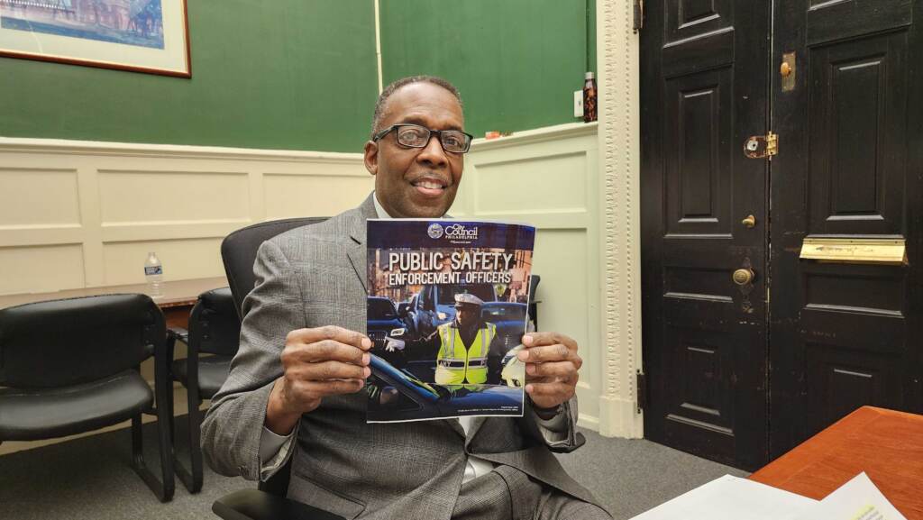 Council President Darrell Clarke holds up an information pamphlet for new jobs. (Tom MacDonald/WHYY)