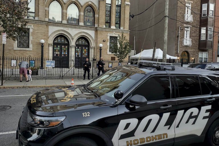 Hoboken Police officers stand watch outside the United Synagogue of Hoboken, Thursday, Nov. 3, 2022, in Hoboken, N.J. The FBI says it has received credible information about a threat to synagogues in New Jersey. The FBI's Newark office released a statement Thursday afternoon that characterizes it as a broad threat. The statement urged synagogues to 