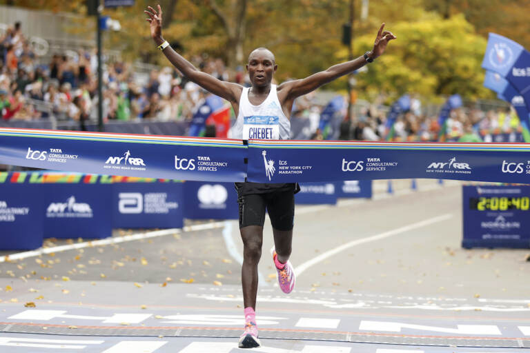 Evans Chebet, of Kenya, crosses the finish line first in the men's division of the New York City Marathon, Sunday, Nov. 6, 2022, in New York. (AP Photo/Jason DeCrow)
