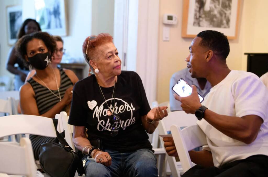 A man holds a microphone up to a woman at the Credible Messenger Film Festival