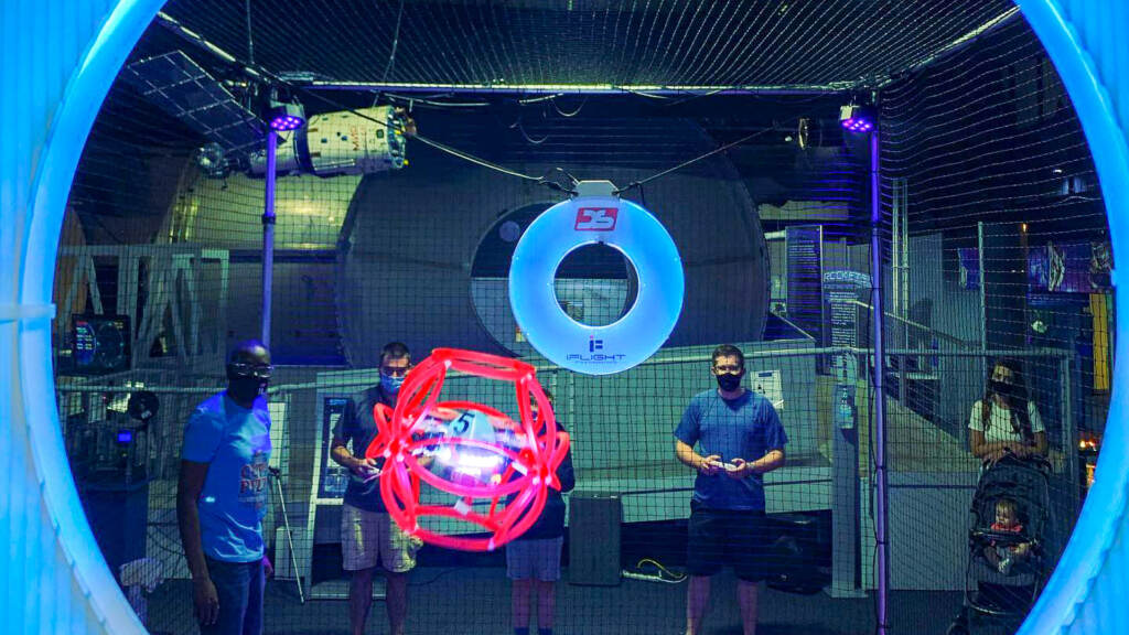 People play a game in front of a screen.