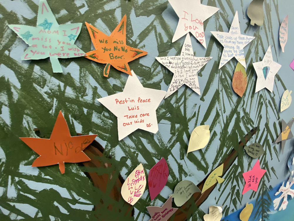 A wall of paper-cut stars with words on them is seen close-up.