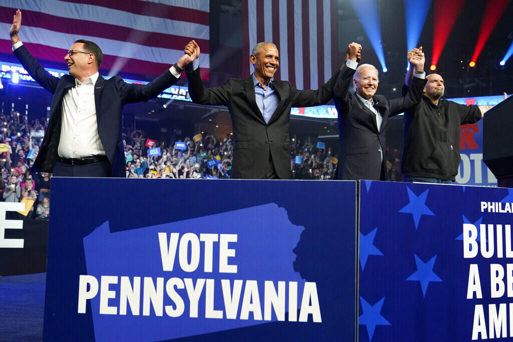Election 2022 Biden Shapiro, Obama, Biden, and Fetterman hold hands in front of a cheering crowd.