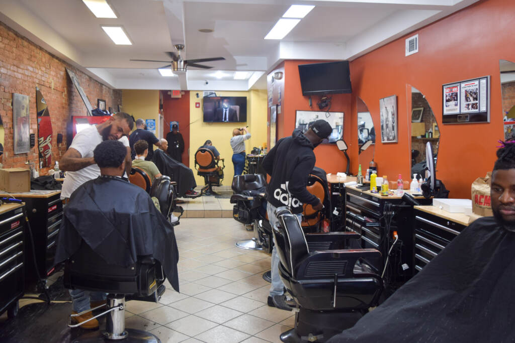 People cut hair inside of a barbershop.
