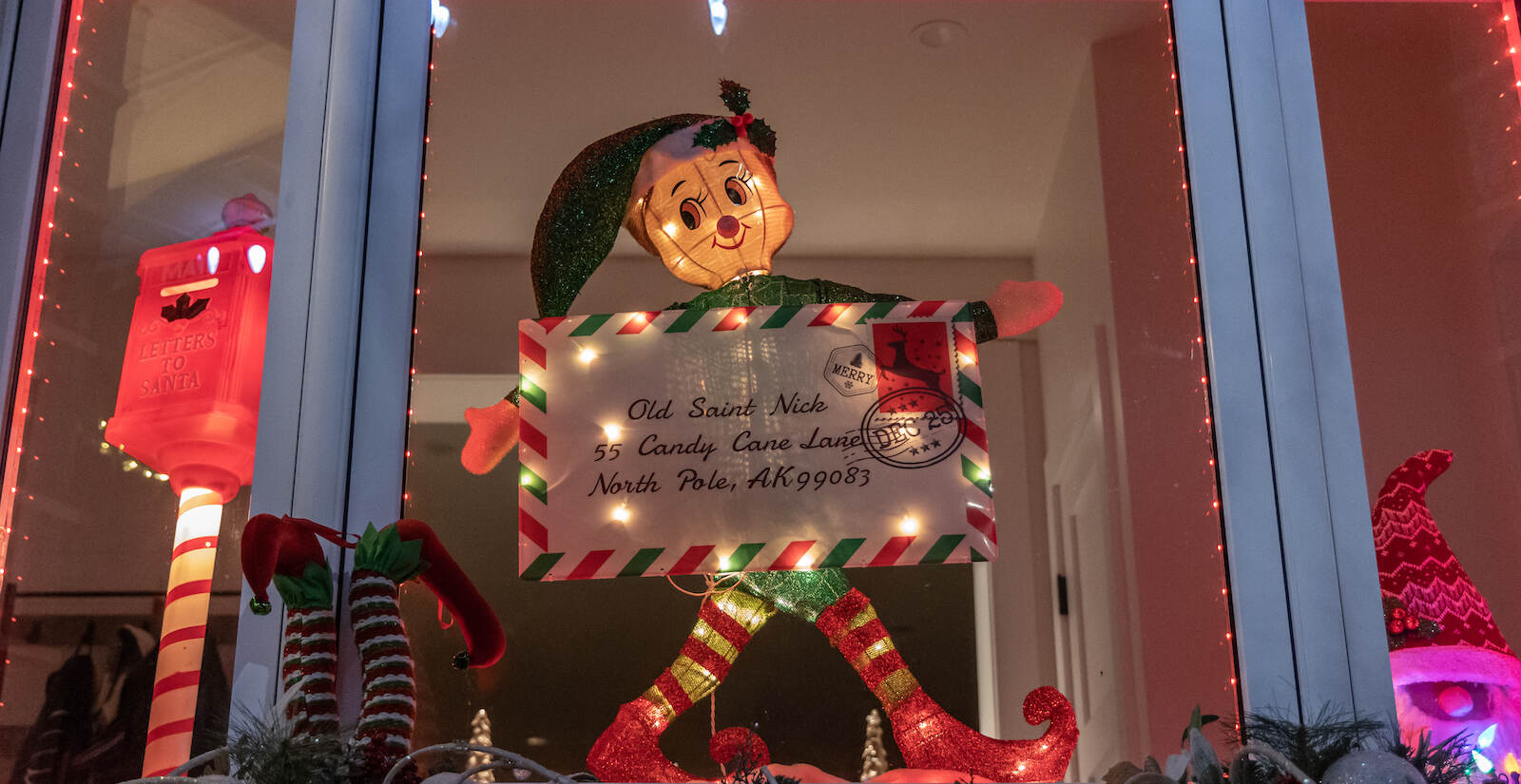 An elf in a South Philly rowhouse window holds a letter addressed to the North Pole