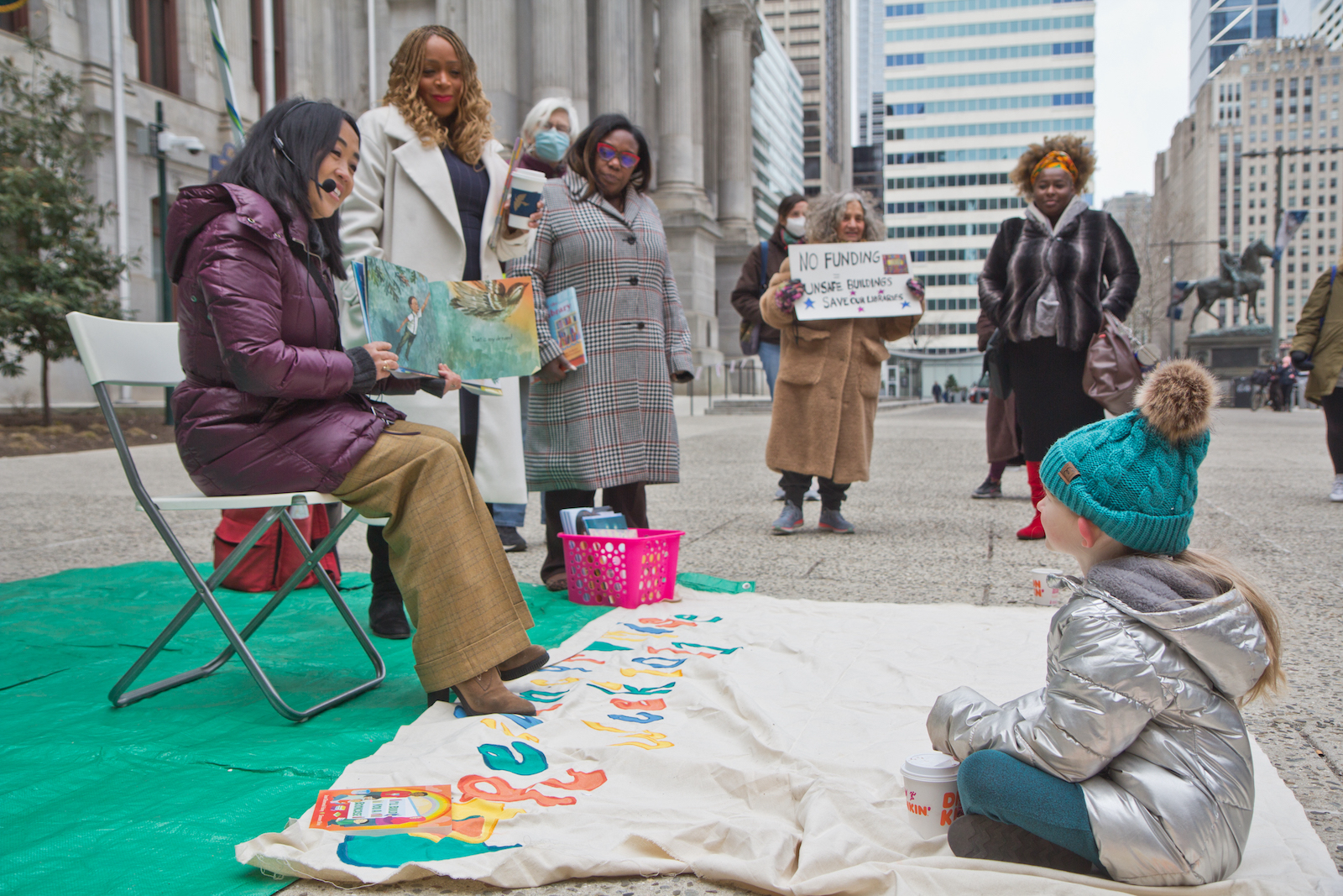 City Councilmember Helen Gym is seen reading to children at a rally outside City Hall