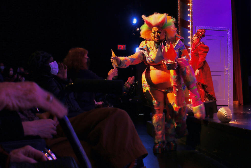 A person dressed as the Cheshire Cat is onstage.
