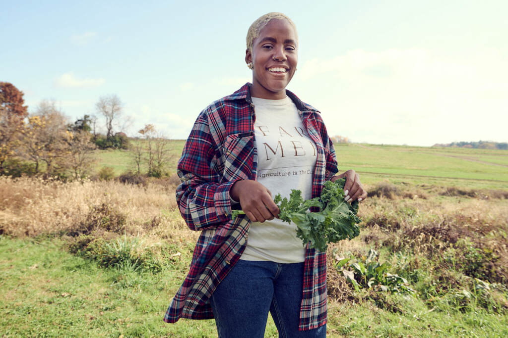 Christa Barfield at Westtown Farm Christa Barfield stands with greens in her hand, with rolling fields in the background.