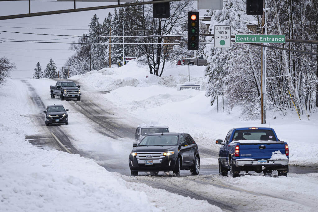 Winter Weather Minnesota Cars are driving on a snow-packed road.