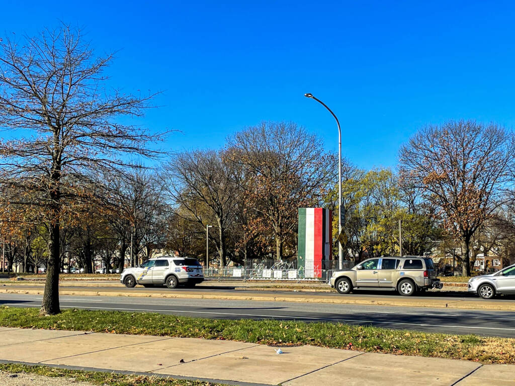 A box painted in white, red, and green is visible from across a street.