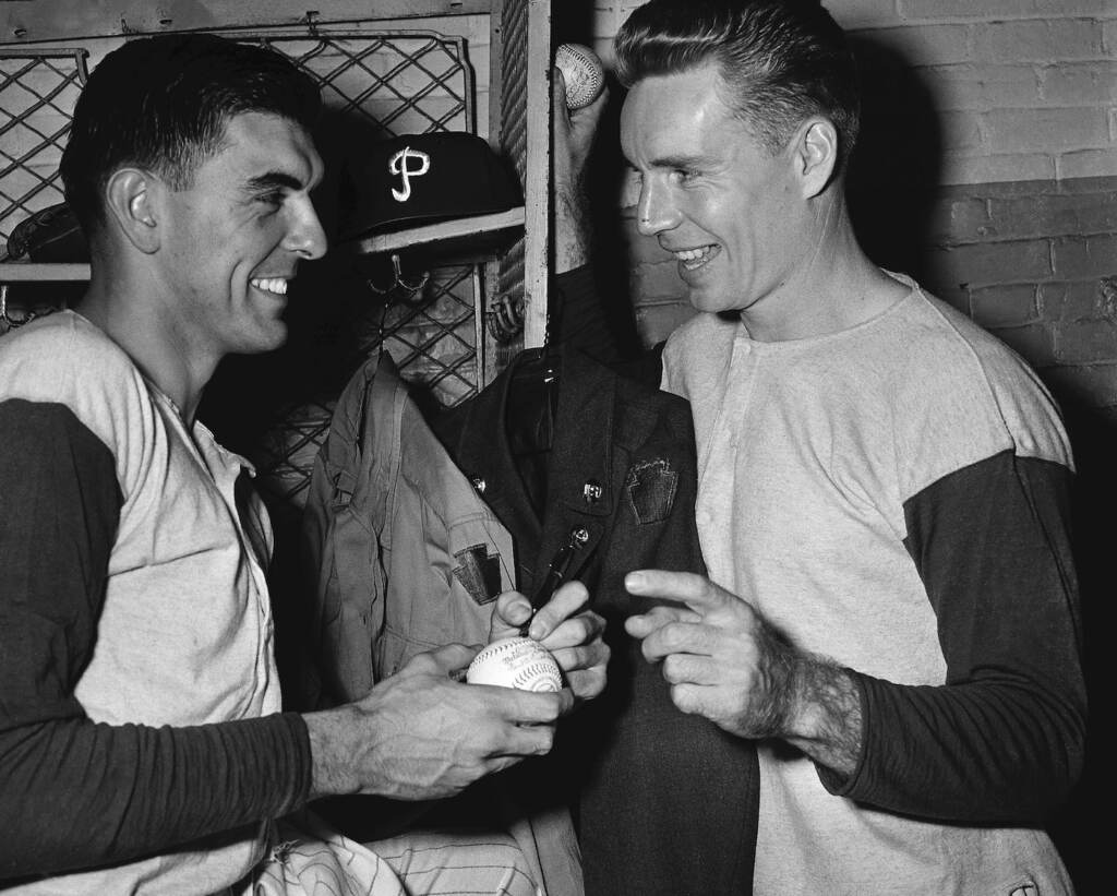 Obit Phillies Simmons Baseball FILE - Philadelphia Phillies' Curt Simmons, left, autographs a ball for teammate John 'Jocko' Thompson before Game 1 of the World Series against the New York Yankees at Shibe Park in Philadelphia, Oct. 4, 1950. Simmons, the last surviving member of the 1950 Philadelphia Phillies 'Whiz Kids' team, died Tuesday, Dec. 13, 2022 in Ambler, Pa. He was 93. (AP Photo/File)