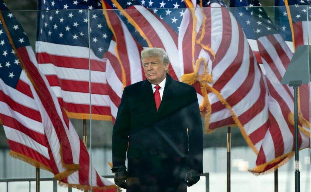 President Trump arrives to speak to supporters from The Ellipse near the White House on Jan. 6, 2021. The rally later turned into a riot that breached the U.S. Capitol. Former President Donald Trump stands in front of numerous U.S. flags.