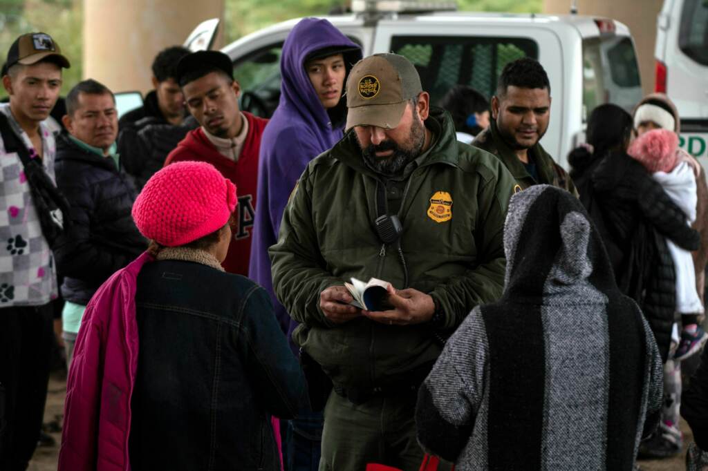 A Border Patrol agent checks an asylum seeker’s passport after she turned herself in, in Eagle Pass, Texas, on Dec. 19. Border Patrol agent checks an asylum seeker's passport after she turned herself in, in Eagle Pass, Texas, on Dec. 19. (Veronica G. Cardenas/AFP via Getty Images)