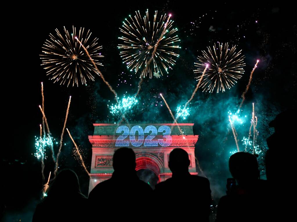 Fireworks explode next to the Arc de Triomphe with ''2023'' projected on the building, at the Avenue des Champs-Elysees during New Year celebrations in Paris. (Julien De Rosa/AFP via Getty Images)