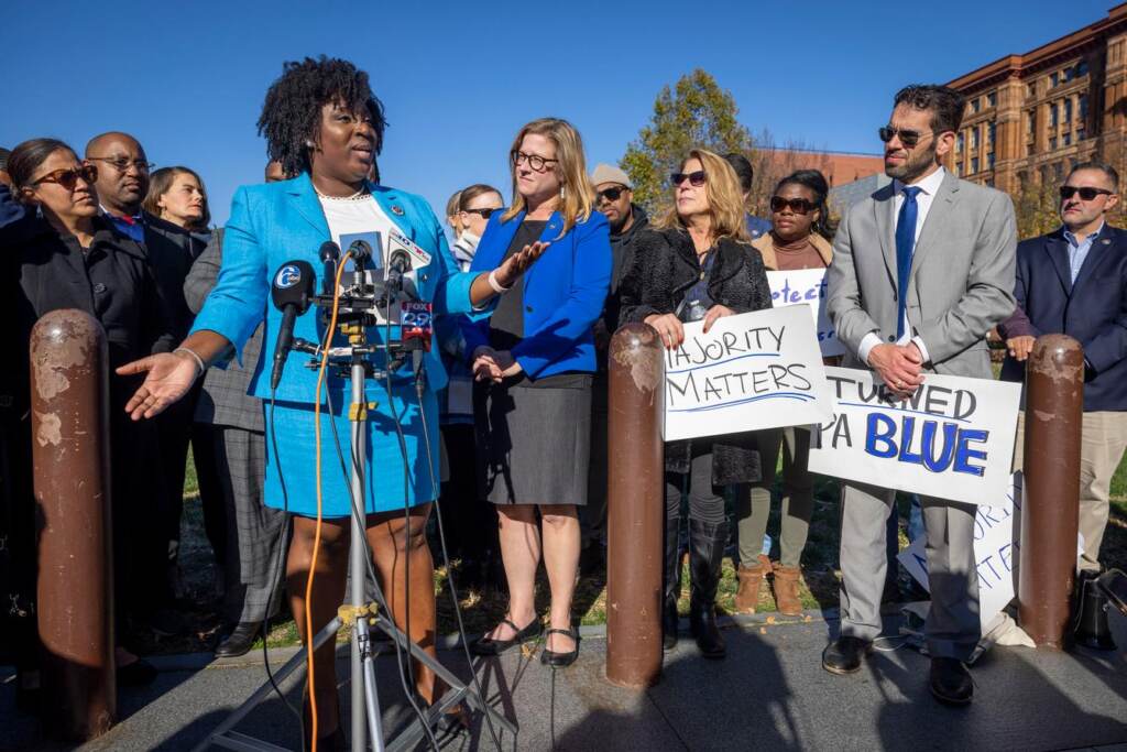 gsemyvp8544t2j5z6rbzv6014c Rep. McClinton speaks at a podium surrounded by other people.