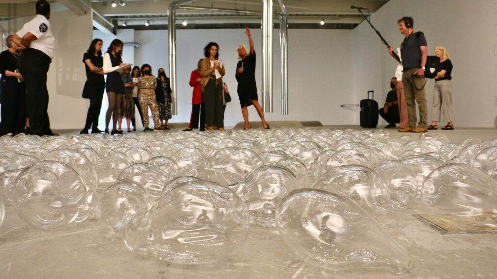 ica-museum-sisseltolaas-03-1024×576 Sissel Tolaas (center) leads members of the media through her exhibit, 'RE______,' at the Institute of Contemporary Art at Penn. Before her lie 365 sealed glass vials containing 365 exhaled breaths. (Emma Lee/WHYY)