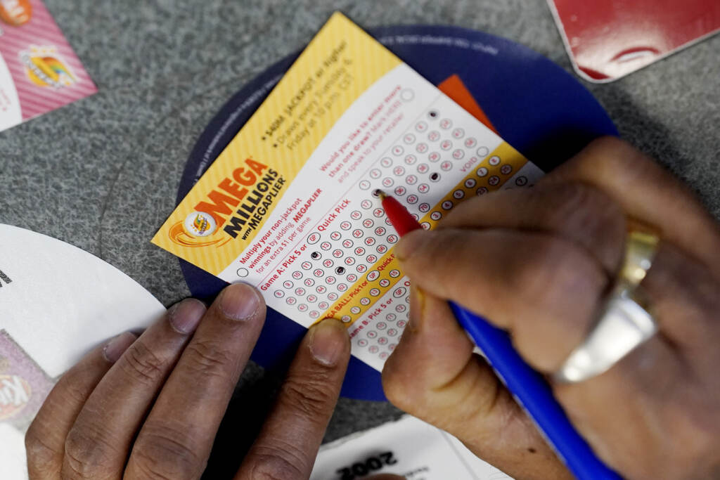 Mega Millions Jackpot A customer fills out a Mega Millions lottery ticket