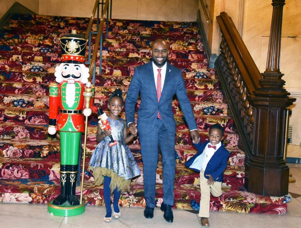 philadelphia-ballet-daddy-and-me-4 A man holds hands with his children next to a giant Nutcracker statue.