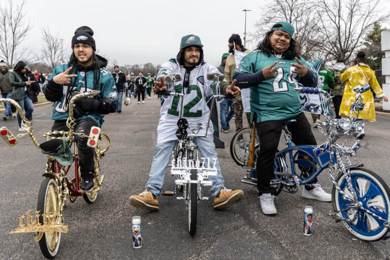Fan Pedro Cartahgena (left), Victor River (center) and Mauricio Vasquez (right) support the Philadelphia Eagles from the tailgate outside the Linc during the NFC East Championship Game on January 29, 2023. (Kimberly Paynter/WHYY)