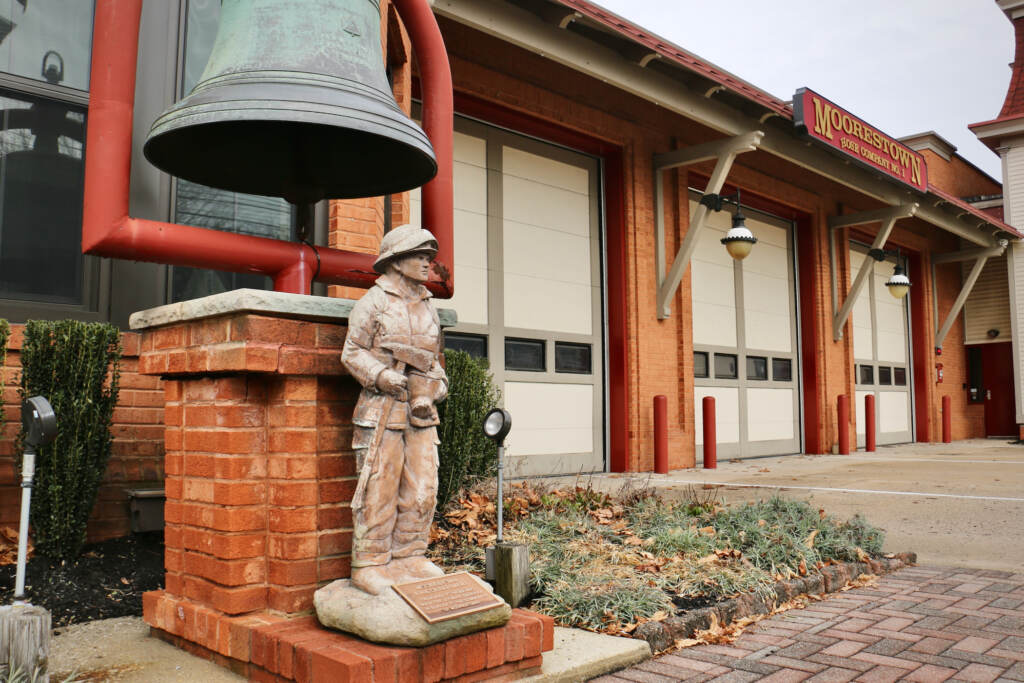Moorestown Fire Department on West Main Street. (Emma Lee/WHYY) A figurine of a firefighter is in the foreground, and the fire station is in the background.