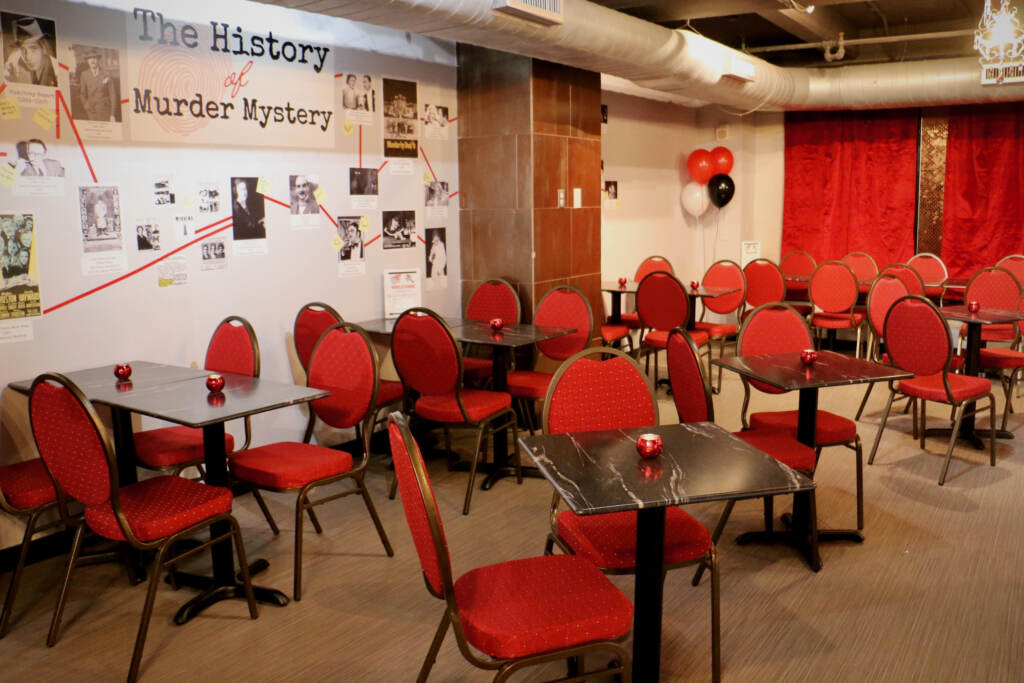 Empty tables and chairs are arranged in a room.