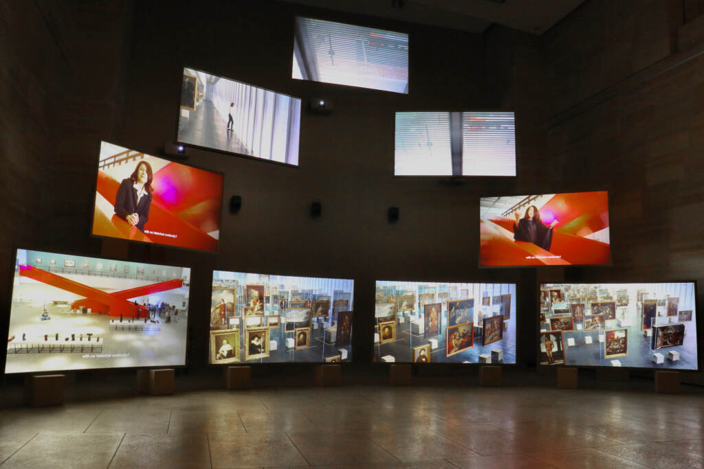 2023 01 25-e lee-isaac julien-philadelphia art museum-lina bo bardi 9 screens A row of screens are displayed in a gallery.