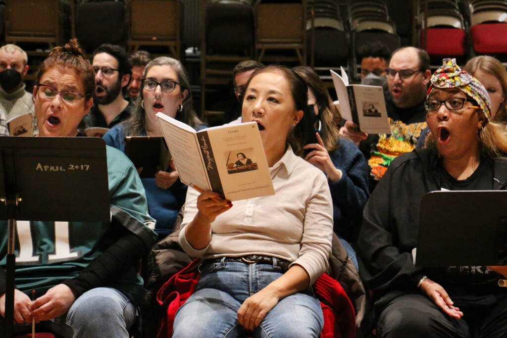 People in a chorus sing.