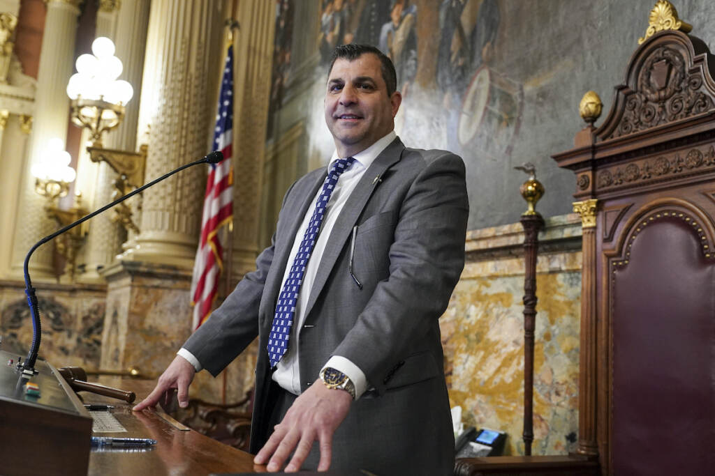 Mark Rozzi smiles, standing at a podium.
